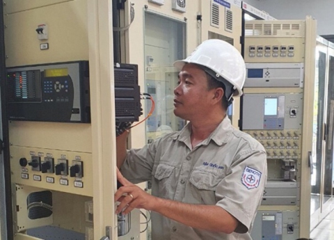 Anh Đặng Quốc Anh (đứng) đang làm việc trong Phòng Điều khiển Trung tâm thuộc Nhà máy Thủy điện An Khê.