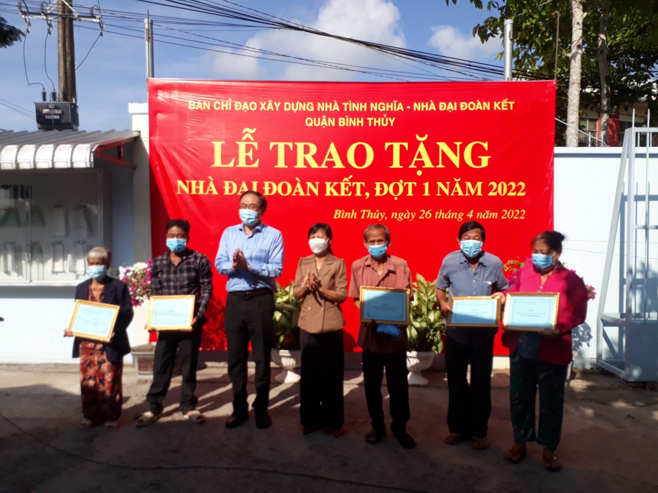 Ông Nguyễn Duy Lăng (thứ ba từ trái sang) trao bảng biểu trưng nhà đại đoàn kết cho các hộ gia đình
